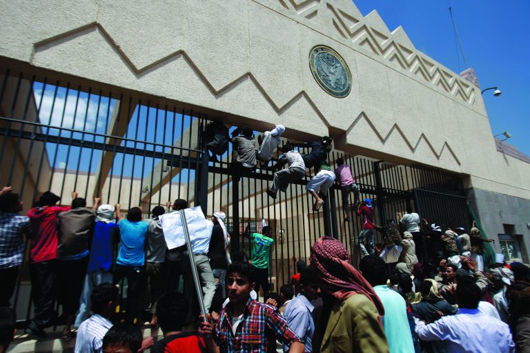 Yemeni protesters climb the gate of the U.S. Embassy during a protest about a film ridiculing Islam's Prophet Muhammad, in Sanaa, Yemen, Thursday, Sept. 13, 2012. Dozens of protesters gather in front of the US Embassy in Sanaa to protest against the American film 