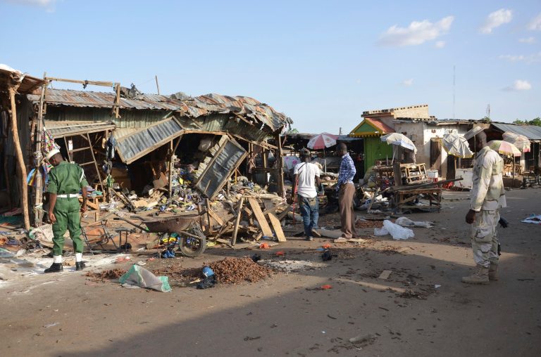 In this Monday June, 22, 2015 file photo, People gather at the site of a suicide bomb attack at a market in Maiduguri, Nigeria. (AP Photo/Jossy Ola, File)