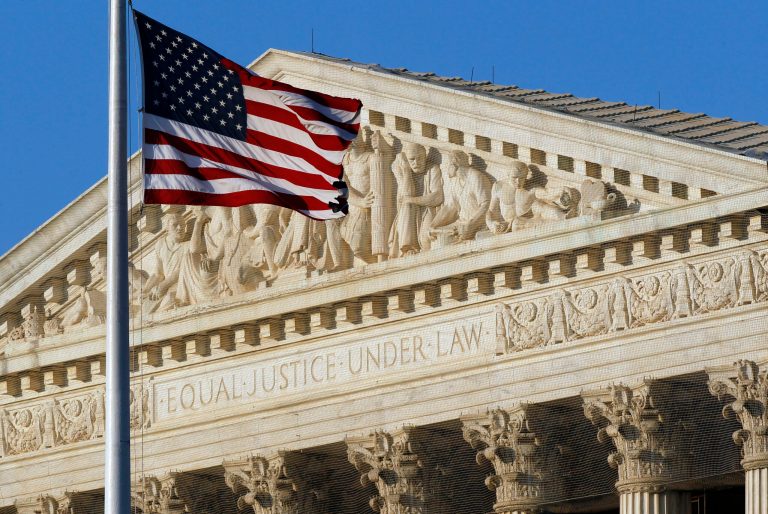 FILE - This June 27, 2012, file photo shows an American flag in front of the U.S. Supreme Court in Washington. It's crunch time at the court, where the justices are racing to issue opinions in 17 cases over the next two weeks. The religious rights of corporations, the speech rights of abortion protesters and the privacy rights of people under arrest are among the significant issues that are so far unresolved as summer beckons Supreme Court justices. (AP Photo/Alex Brandon, File)