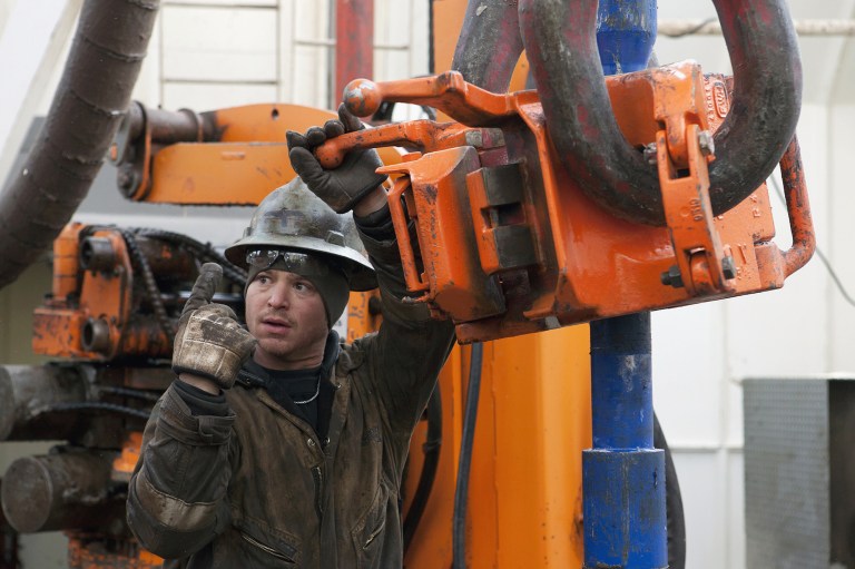 FILE - In this Dec. 5, 2013 file photo, Russell Girsh motions to his driller to turn the equipment on at an oil rig near Watford City, N.D. Job Service North Dakota data show counties that produced oil last year held nine of the top 10 spots in average annual wages. Research analyst Michael Ziesch says North Dakota's average annual wage increased about 4 percent last year to almost $48,000. Ziesch says the state's average wage still lags behind the national average of just over $49,000. (AP Photo/Williston Herald, Jerry Burnes, File)