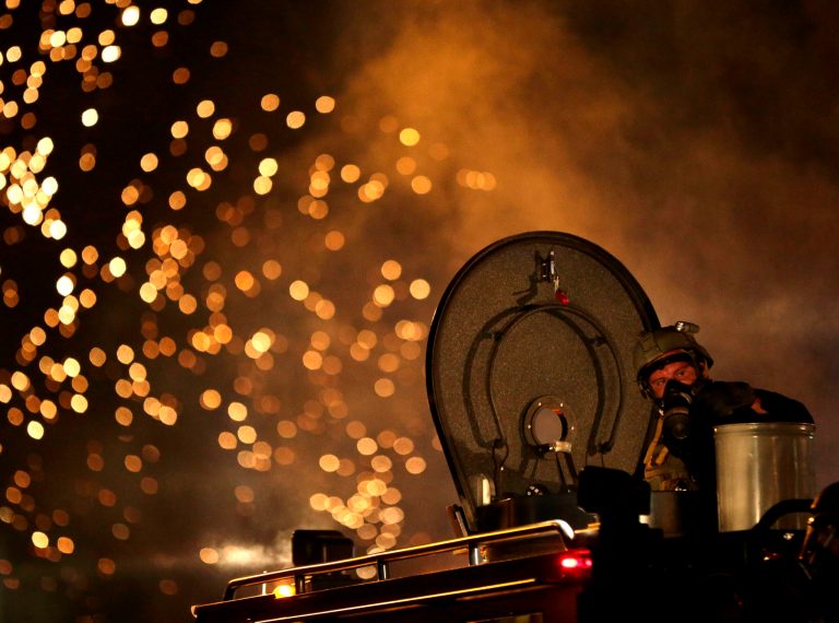 A law enforcement officer watches from an armored vehicle after a device was fired to disperse a crowd during a protest for Michael Brown, in Ferguson, Mo., in this Aug. 17, 2014 file photo. (AP Photo/Charlie Riedel, File)