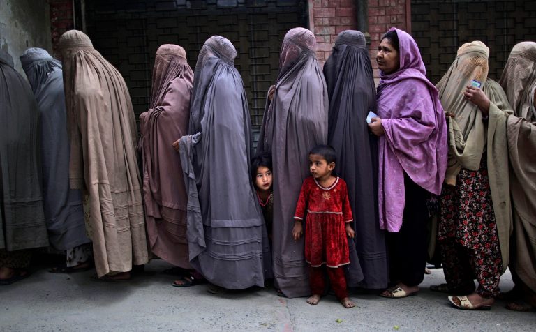 Pakistani women line up to enter a polling station and cast their ballots, on the outskirts of Islamabad, Pakistan, Saturday, May 11, 2013. Pakistanis streamed to the polls Saturday to vote in a historic election pitting a cricket star-turned-politician against an unpopular incumbent and a two-time prime minister, but twin bombings killing nine people and wounding dozens underlined the dangers voters face. (AP Photo/Muhammed Muheisen)