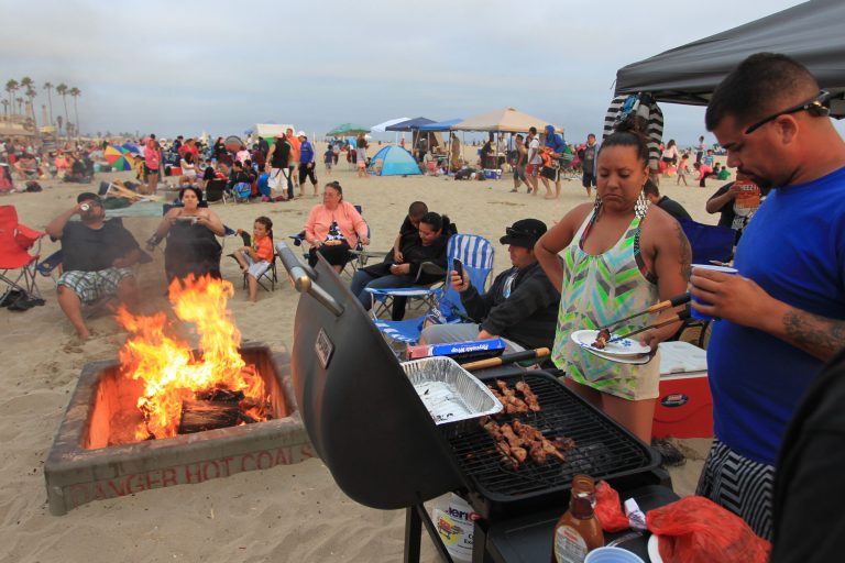 Beach goers barbecue and gather around traditional beach bonfires on July 6, 2013 in Huntington Beach, Calif. (Photo by David McNew/Getty Images)