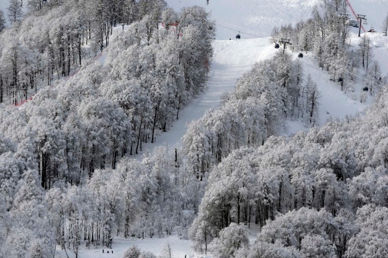 A gondola passes a stand of trees after an overnight dusting of snow during snowboard parallel giant slalom qualifying at the Rosa Khutor Extreme Park, at the 2014 Winter Olympics, Wednesday, Feb. 19, 2014, in Krasnaya Polyana, Russia. (AP Photo/Andy Wong)