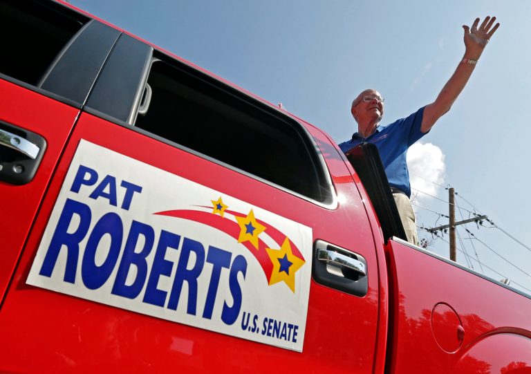 Sen. Pat Roberts waves to the crowd as he rides on the back of a pickup in a parade Saturday in Gardner, Kan. (AP Photo/Charlie Riedel)