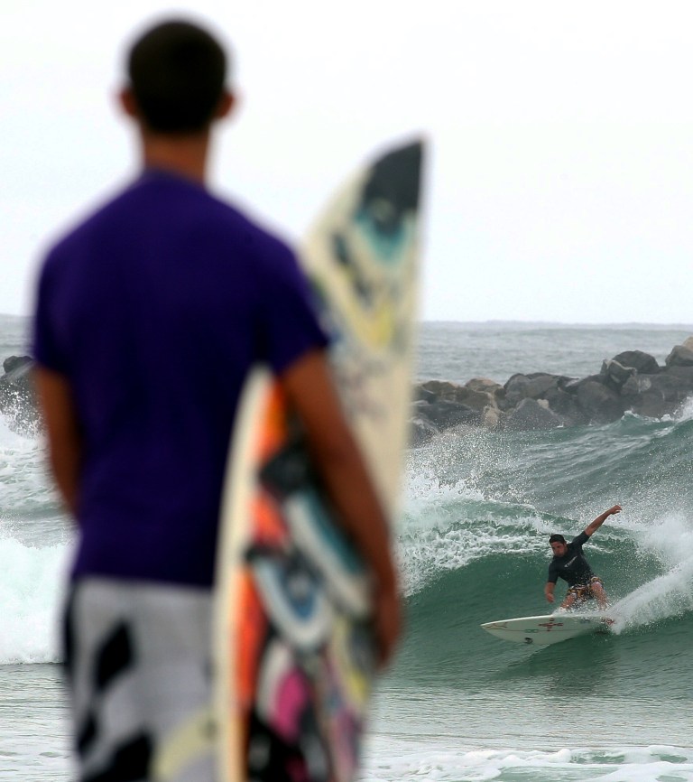 Kyle Richardson, 17, watches as another surfer rides a wave generated by Tropical Storm Andrea in Panama City Beach, Fla. on Thursday, June 6, 2013. Heavy rain poured down on much of Florida Thursday as the first tropical storm of the Atlantic hurricane season headed toward the state's western coast, while a new tropical storm warning was issued for a swath of the U.S. East Coast. (AP Photo/The News Herald, Andrew Wardlow)