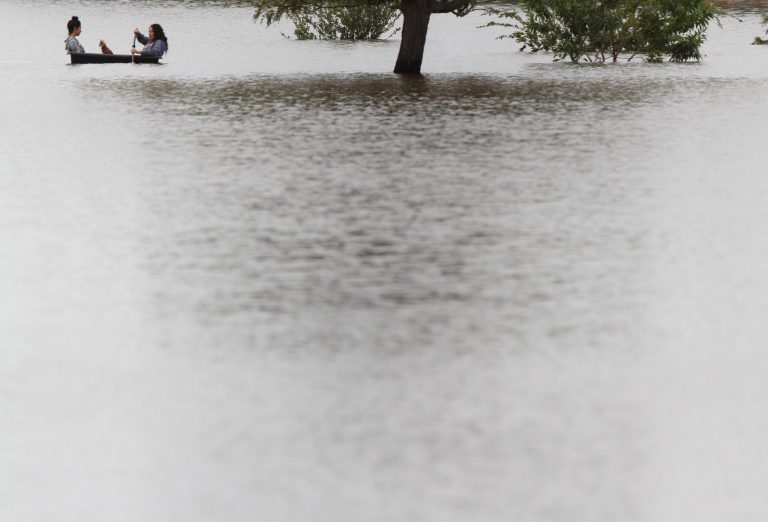 FILE - In this Sept. 18, 2014 file photo, two girls and their dog make their way in a small boat in the flooded ponding area at Album Park in El Paso, Texas. The city experienced heavy overnight rains which flooded streets and caused overflows at collection sites such as Album Park. Texas continues to grind its way out of drought, helped by recent steady rains statewide and in the next few months by an El Nino weather pattern that promises to bring plentiful rain through winter, a National Weather Service forecaster says.(AP Photo/El Paso Times, Victor Calzada, File)