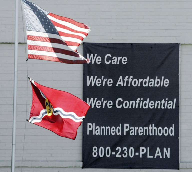 Flags fly near a sign at Planned Parenthood of the St. Louis Region in June 2004. (AP Photo/James A. Finley)