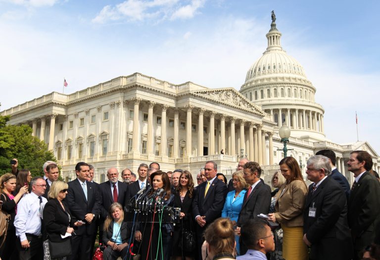 FILE - In this May 16, 2013 file photo Rep. Michele Bachmann, R-Minn., chair of the Tea Party Caucus, center, speaks during a news conference with Tea Party leaders about the IRS targeting Tea Party groups on Capitol Hill in Washington. Shouts of vindication from around the country suggest tea party movement's leaders think it is getting its groove back. They say the IRS acknowledgement that it had targeted their groups for extra scrutiny is helping pump new energy into the coalition. (AP Photo/Molly Riley, File)