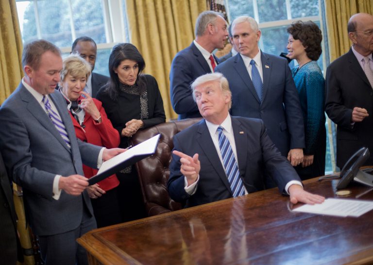 President Donald Trump looks over towards Budget Director Mick Mulvaney, left, after signing an executive order in the Oval Office of the White House in Washington, Monday, March 13, 2017. Trump signed 