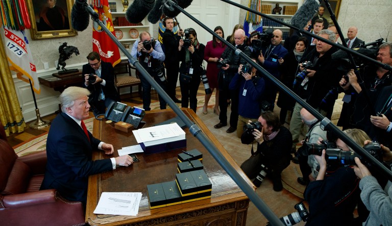 President Trump speaks with reporters after signing the tax bill and continuing resolution to fund the government in the Oval Office. (AP Photo/Evan Vucci)