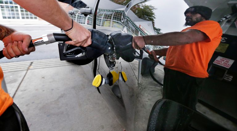 FILE - In this Sept. 30, 2014 file photo, Dana Ripley, of Winthrop, Mass., fills the gas tank of his truck at a service station in Andover, Mass. A swoon in the price of oil is lowering fuel bills for drivers, shippers and airlines, but it is not without downsides for both the U.S. oil boom and the broader economy. (AP Photo/Charles Krupa, File)