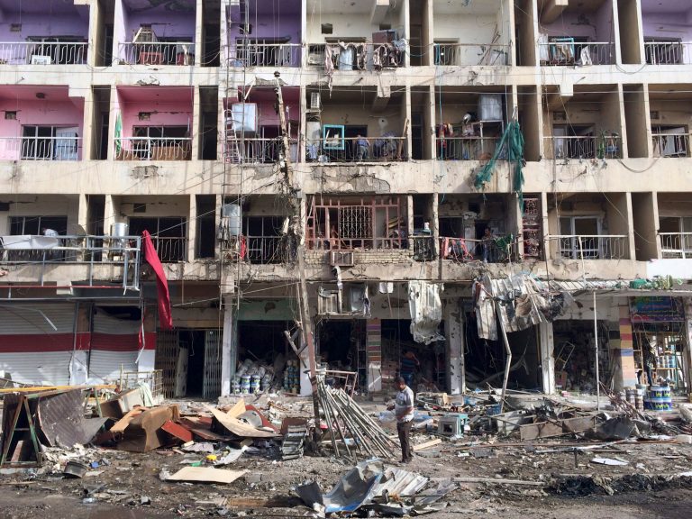 Iraqi civilians inspect the aftermath of a car bombing in the southeastern district of New Baghdad, Iraq. (AP/Khalid Mohammed)