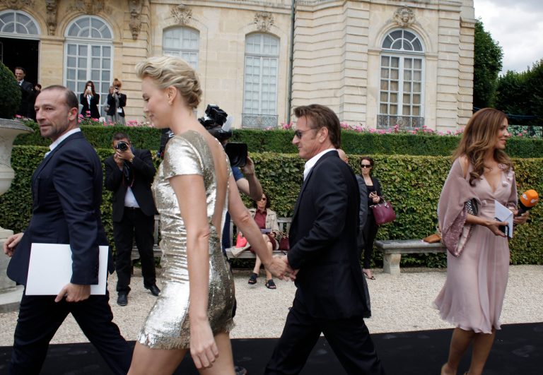 Actress Charlize Theron and actor Sean Penn arrive hand in hand at Dior's Fall-Winter 2014-2015 Haute Couture fashion collection, in Paris, France, Monday, July 7, 2014. (AP Photo/Thibault Camus)