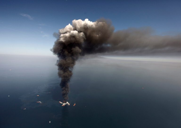 FILE -  In this Wednesday, April 21, 2010 file photo, oil can be seen in the Gulf of Mexico, more than 50 miles southeast of Venice on Louisiana's tip, as a large plume of smoke rises from fires on BP's Deepwater Horizon offshore oil rig. An April 20, 2010 explosion at the offshore platform killed 11 men, and the subsequent leak released an estimated 172 million gallons of petroleum into the gulf. U.S. District Judge Carl Barbier ruled Thursday, Sept. 4, 2014, in New Orleans, La., that BP acted recklessly and bears most of the responsibility for the oil spill. The ruling exposes BP to about $18 million in civil fines under the Clean Water Act. (AP Photo/Gerald Herbert, File)