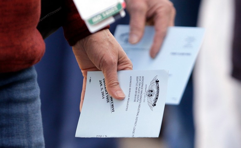Boeing machinists holding their completed ballots head to their polling place at a union hall on Friday in Everett, Wash. (AP Photo/Elaine Thompson)