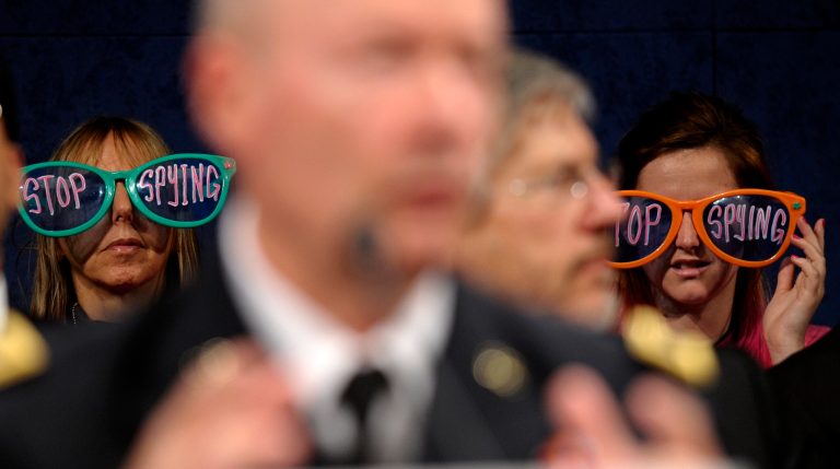Protestors listen as National Security Agency Director Gen. Keith Alexander, center, testifies on Capitol Hill in Washington. (AP/Susan Walsh)