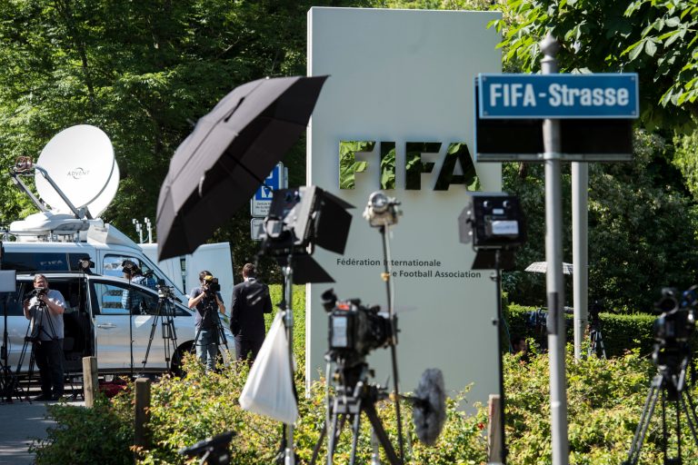 Journalists wait in front of the FIFA logo at the FIFA headquarters in Zurich, Switzerland, Wednesday, June 3, 2015. (Ennio Leanza/Keystone via AP)
