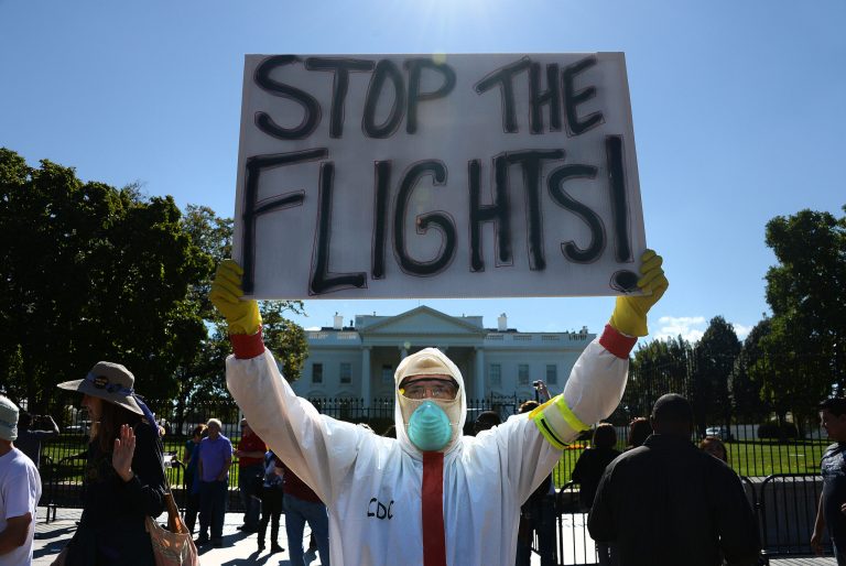 A protester stands outside the White House asking President Obama to ban flights in effort to stop Ebola. (Olivier Douliery/Pool via CNP)