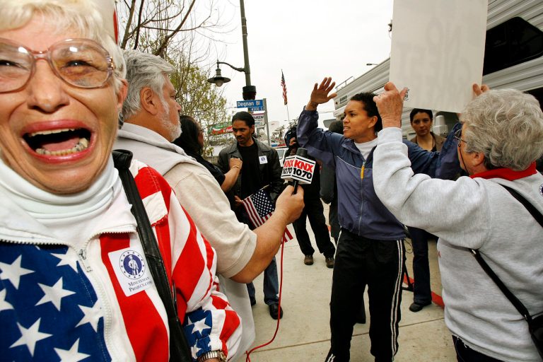 FILE - In this May 3, 2006, file photo, Barbara Coe, far left, and Elaine Proko, far right, Minuteman Project supporters, argue with Monica Morant, center, in South Los Angeles. The Minuteman Project, volunteers who patrol the border and oppose illegal immigration, kicked off their cross-country caravan hoping to mobilize voters. Barbara Coe, who co-sponsored California's Proposition 187 measure on illegal immigration, has died. She was 79. (AP Photo/Ric Francis, File)