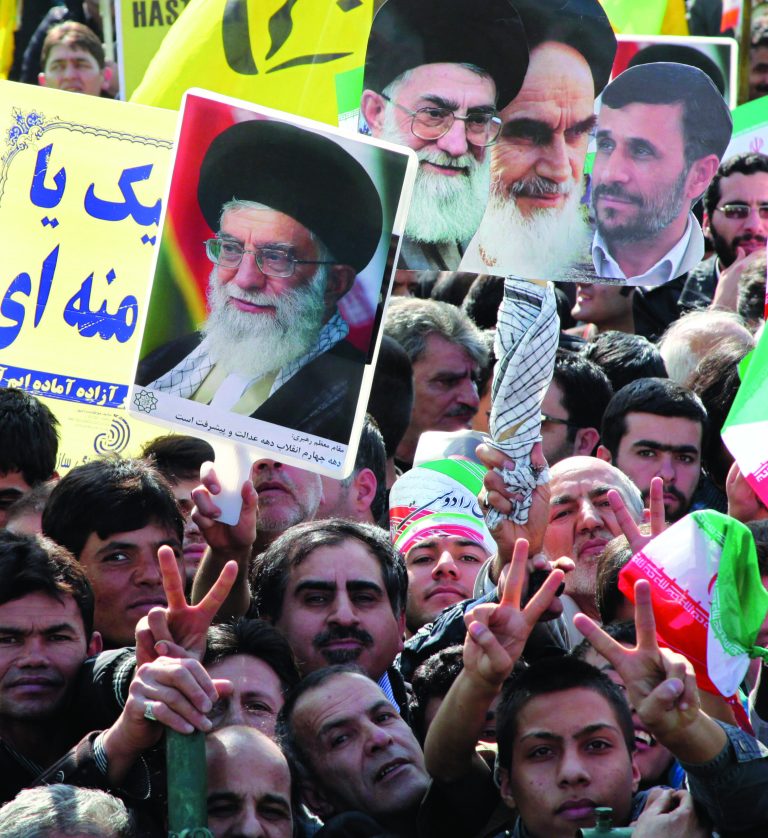 Iranians flash the victory sign as they hold posters showing President Mahmoud Ahmadinejad, right, late Ayatollah Khomeini, second right, and Supreme Leader Ayatollah Ali Khamenei, center and left, at a rally commemorating the anniversary of 1979 Islamic revolution that toppled the country's pro-Western monarchy and brought Islamic clerics to power, in Azadi Square, Tehran, Iran, Sunday, Feb. 10, 2013. In his statements to the rally, Ahmadinejad said he is ready to have direct talks with United States if the West stops pressuring his country. (AP Photo/Vahid Salemi)