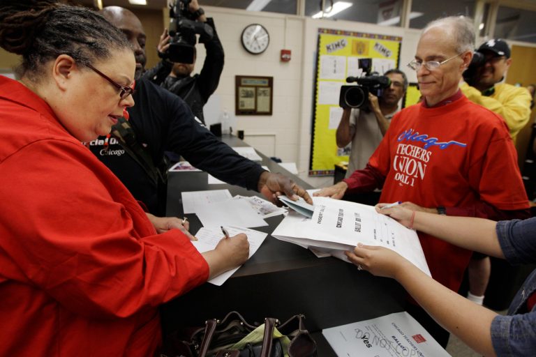Chicago Teachers Union President Karen Lewis, left, registers for her ballot during a strike authorization vote at a high school in Chicago. (AP Photo/M. Spencer Green,File)

