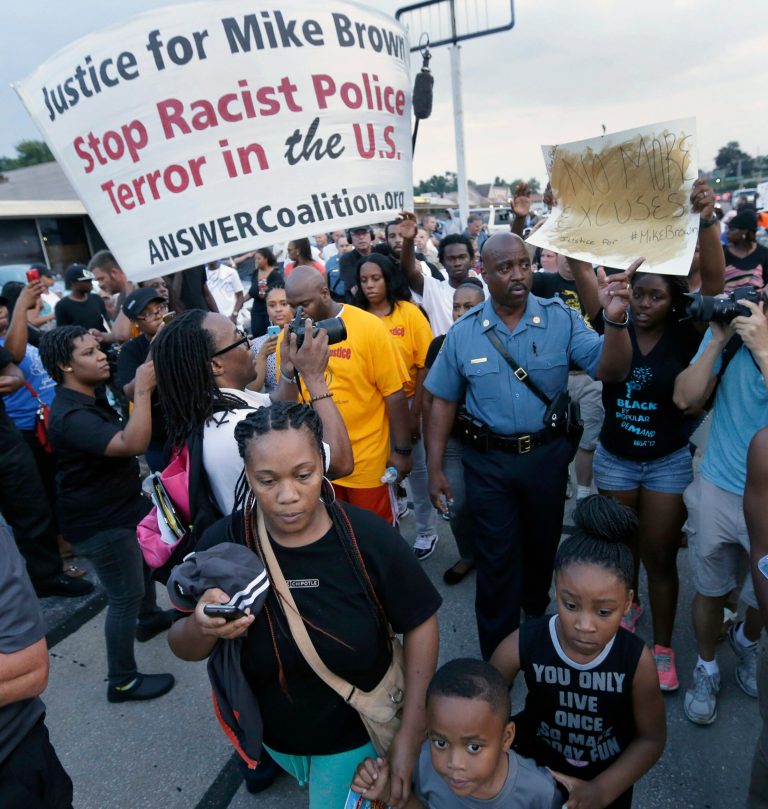 FILE - In this Aug, 16, 2014 file photo, Missouri Highway Patrol Capt. Ron Johnson walks among people protesting the police shooting death of Michael Brown a week ago in Ferguson, Mo. The Ferguson City Council, set to meet Tuesday, Sept. 9, 2014, for the first time since the fatal shooting of Brown, said it plans to establish a review board to help guide the police department and make other changes aimed at improving community relations. (AP Photo/Charlie Riedel, File)