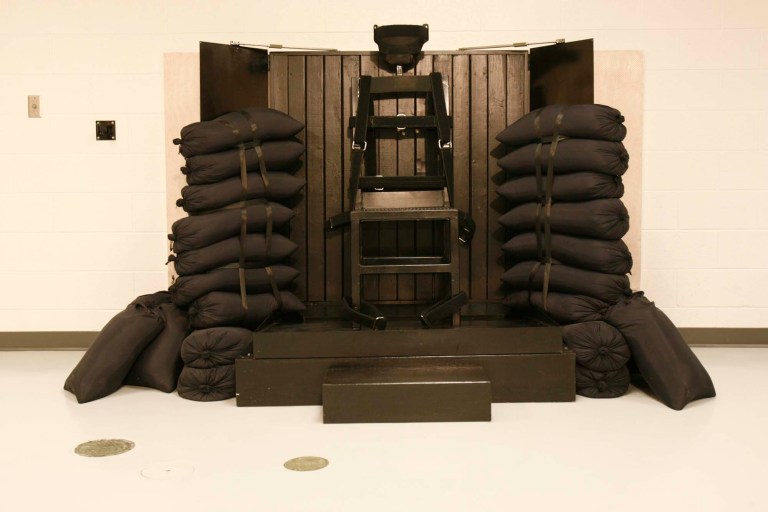 The execution chamber at the Utah State Prison after Ronnie Lee Gardner was executed by firing squad Friday, June 18, 2010. The bullet holes are visible in the wood panel behind the chair. Gardner was convicted of aggravated murder, a capital felony, in 1985. (AP Photo/Trent Nelson - Pool)