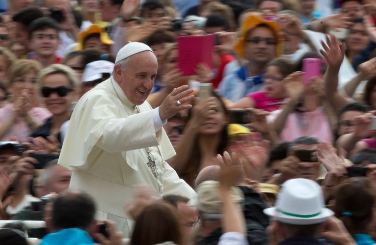 Pope Francis waves as he is driven through the crowd during his weekly general audience in St. Peter's Square at the Vatican, Wednesday, June 25, 2014. (AP Photo/Alessandra Tarantino)