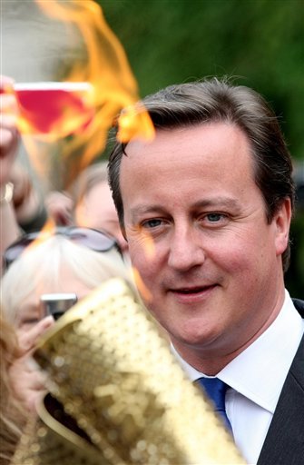 British Prime Minister David Cameron watching the Olympic Flame pass (AP Photo)