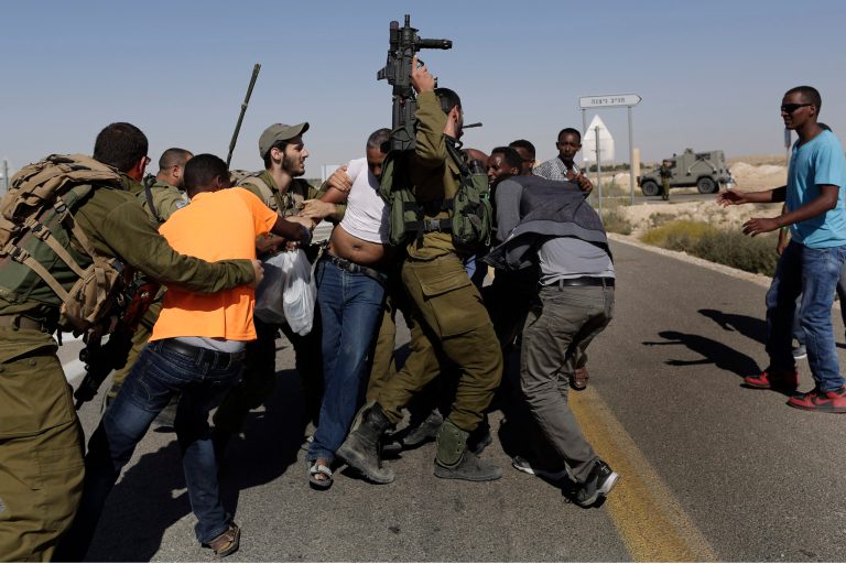 African migrants clash with Israeli soldiers after they left Holot detention center in southern Israel and walked towards the border with Egypt near the southern Israeli Kibbutz of Nitzana in 2014. Israel build an effective fence to stop the illegal migration that the U.S. is studying for its new border wall. (AP Photo/Tsafrir Abayov)