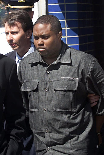 Police lead John Taylor, right, out of a police station in the Queens borough of New York, on May 28, 2000. (Photo: Ed Betz/AP file)