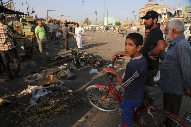 Iraqi civilians gather the morning after a car bombing that killed many people and wounded tens of others in a crowded outdoor market in the Shiite neighborhood known as Sadr City, Baghdad, Iraq, Wednesday. (AP Photo/Karim Kadim)