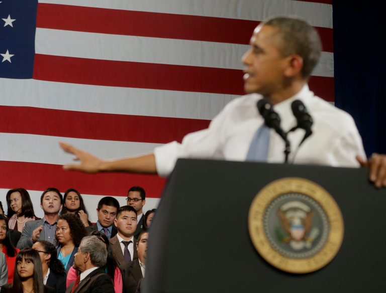 President Barack Obama, right, gestures as he attempts to respond to a unidentified man, lower left, who began to heckle him about anti-deportation policies, Monday, at the Betty Ann Ong Chinese Recreation Center in San Francisco. (AP Photo/Pablo Martinez Monsivais)