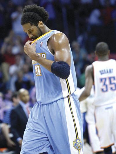 Denver Nuggets center Nene, of Brazil, walks off the court and wipes his face with his jersey during a time-out in the fourth quarter of an NBA basketball game against the Oklahoma City Thunder in Oklahoma City, Friday, April 8, 2011. Thunder forward Kevin Durant, right, look on. Oklahoma City won 104-89.(AP Photo/Sue Ogrocki)