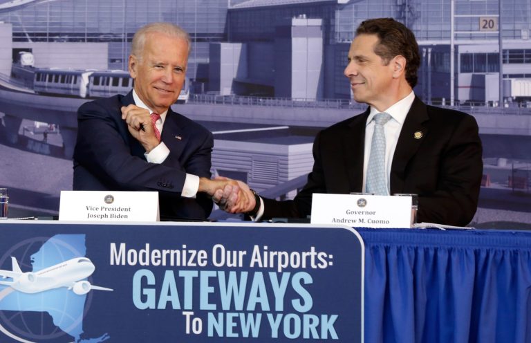 Vice President Joe Biden, left, shakes hands with New York Gov. Andrew Cuomo, in a hangar of the Vaughn College of Aeronautics and Technology, in New York,  Monday, Oct. 20, 2014, during a presentation to discuss the need to improve New York's airports. Biden joined Cuomo as the governor announced a design competition to modernize and improve New York City's John F. Kennedy and LaGuardia Airports. (AP Photo/Richard Drew)