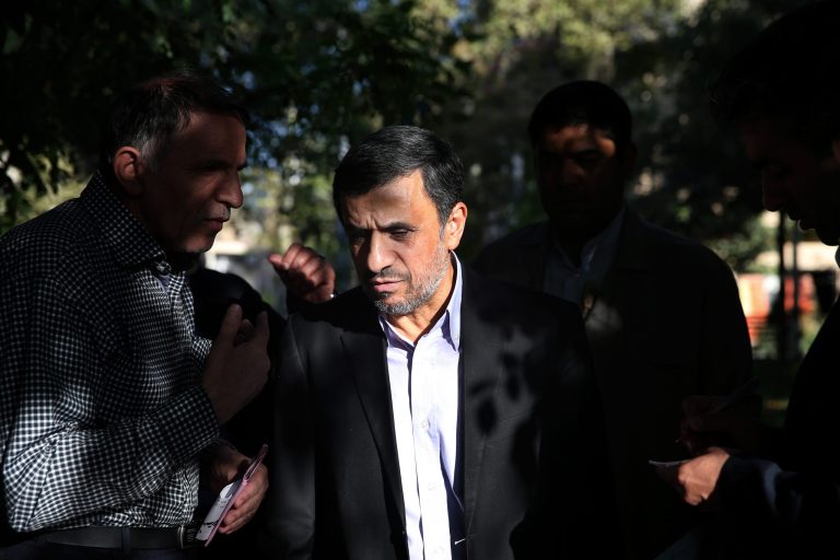 Former Iranian President Mahmoud Ahmadinejad, center, talks with a man after receiving his petition for help outside his house in northeastern Tehran, Iran, Monday, Aug. 3, 2015. (AP Photo/Ebrahim Noroozi)