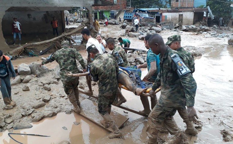 Colombian National Army soldiers carry a victim on a stretcher, in Mocoa on Saturday, April 1, after an avalanche of water from an overflowing river swept through the city as people slept. (Colombian Army Photo via AP)
