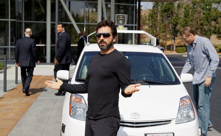 FILE - In this Sept. 25, 2012, file photo, Google co-founder Sergey Brin gestures after riding in a driverless car with officials, to a bill signing for driverless cars at Google headquarters in Mountain View, Calif. Google engineers say they have turned a corner in their pursuit of creating a car that can drive itself. Test cars have been able to navigate freeways comfortably for a few years. On Monday, April 28, 2014, Google said the cars can now negotiate thousands of urban situations that would have stumped them a year or two ago.  (AP Photo/Eric Risberg, File)