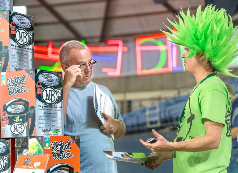 Dale Rennaker of Vancouver talks with Chris Whitener, a Magic Butter company service representative about the MB2 magical butter machine during the first 