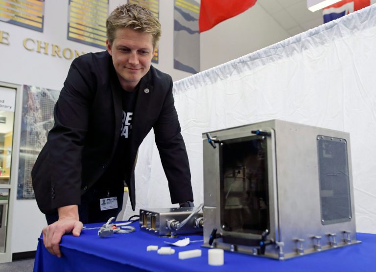 Brad Kohlenberg, a business development engineer with Made In Space, looks over  a 3-D printer identical to the one that will be transported to the International Space Station aboard the Falcon 9 SpaceX rocket at the Kennedy Space Center in Cape Canaveral, Fla., Friday, Sept. 19, 2014. NASA is sending a 3-D printer to the International Space Station in hopes that astronauts will be able to one day fix their spacecraft  by cranking out spare parts on the spot. (AP Photo/John Raoux)