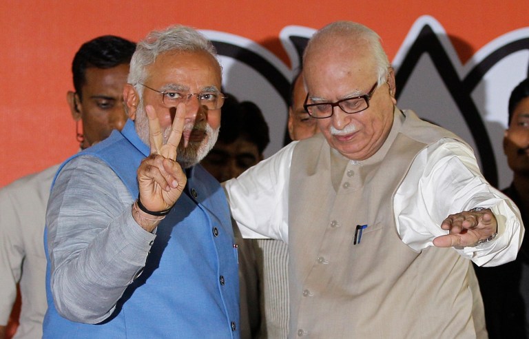 Opposition Bharatiya Janata Party (BJP) leader and India's next prime minister Narendra Modi, left, flashes the victory symbol standing next to senior party leader L.K. Advani at the party headquarters in New Delhi, India, Saturday, May 17, 2014. Thousands of cheering supporters welcomed Modi on his arrival in the capital Saturday after leading his party to a staggering victory in national elections. Modi and his BJP wiped out the Congress party that dominated Indian politics for all but a decade since the country gained freedom from British rule in 1947. (AP Photo/Altaf Qadri)