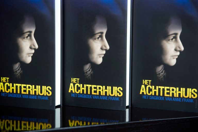 In this photo taken Friday, May 2, 2014 copies of Anne Frank's diary are on display during an interview with the Associated Press at Theater Amsterdam. Seeking to engage a new generation with the tragic story of Anne Frank, a major new play based on the Jewish teenager's diary opens Thursday, May 8, 2014 in Amsterdam. It's the first time a theatrical production has been forged directly from Frank's actual writings since the award-winning 1950s play that escalated her story, then little-known, to the world's attention. It's being staged in a purpose-built 1,100 seat theater that includes a replica of the secret apartment where Frank and her family hid from the Nazis in World War II. (AP Photo/Evert Elzinga)