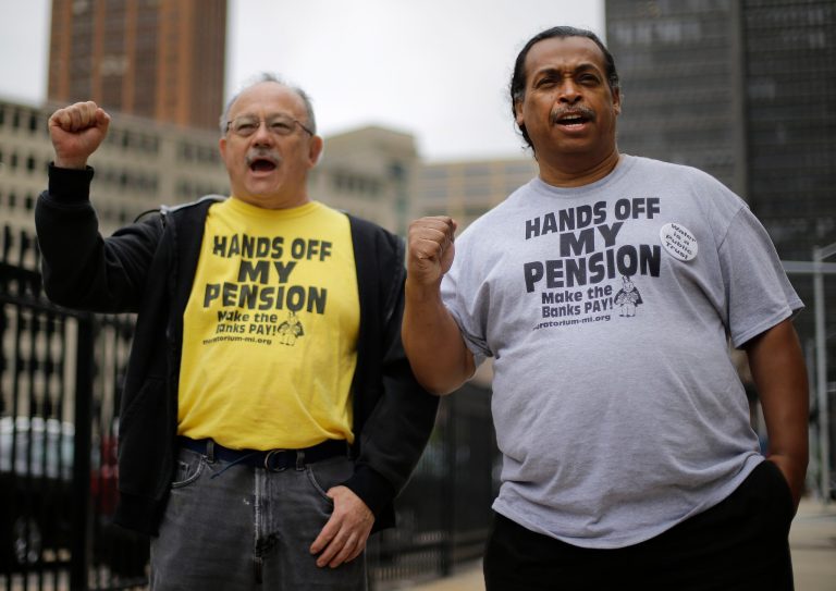FILE - In a Thursday, July 3, 2014 file photo, Detroit retirees Mike Shane, left, and William Davis protest near the federal courthouse in Detroit. Workers and retirees approved pension cuts in Detroit's bankruptcy by a landslide, the city reported Monday, a crucial step to emerging from the largest municipal insolvency in U.S. history. The city disclosed results from two months of balloting, which ended July 11. Judge Steven Rhodes still must hold a trial in August to determine if Detroit's overall bankruptcy plan is fair and feasible to all creditors, from Wall Street to Main Street, but support from retirees is vital. (AP Photo/Paul Sancya, File)