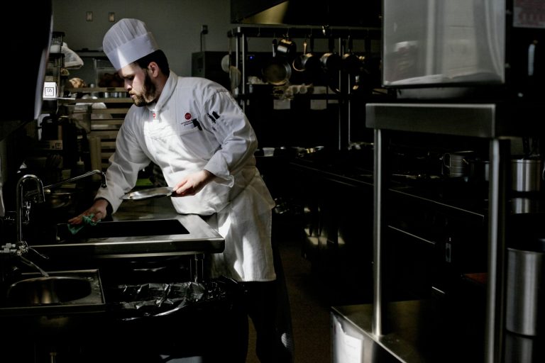 In this photo taken on Thursday, April 17, 2014, Shawn Kraft sanitizes a surface before preparing a dish at the Courses restaurant at Baker College Culinary Institute of Michigan in Port Huron, Mich. Courses provides students hands-on experience with a restaurant environment (AP Photo/The Port Huron Times Herald, )Jeffrey Smith  NO SALES