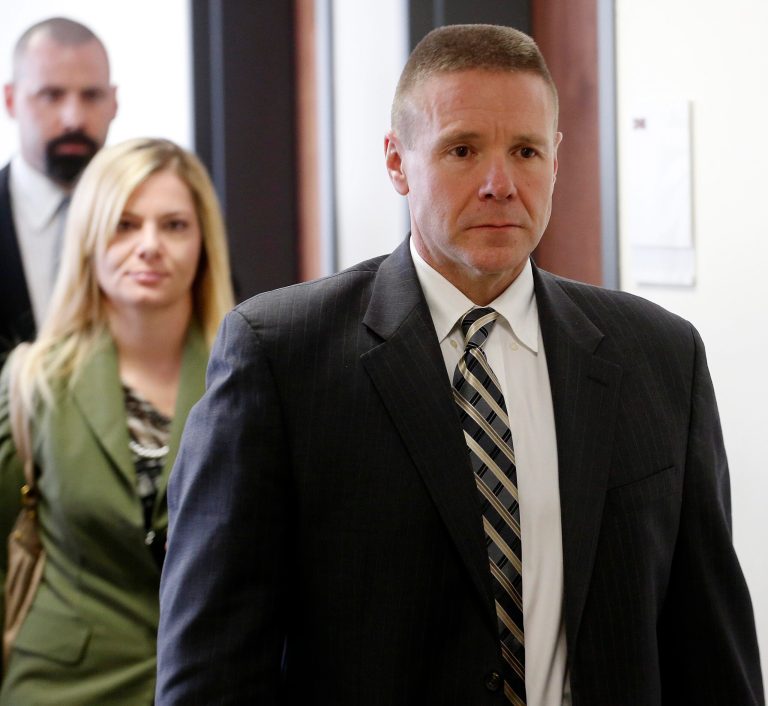 Brett Mills, front, an FBI crime scene expert leaves the courtroom for a hearing for Aurora theater shooting suspect James Holmes at district court in Centennial, Colo., on Friday Jan. 31, 2014. Mills was on the stand when the judge recessed for lunch.  Holmes has pleaded not guilty by reason of insanity to charges of killing 12 people and injuring 70 at a Denver-area movie theater in July 2012. Prosecutors are seeking the death penalty. (AP Photo/Ed Andrieski, Pool)