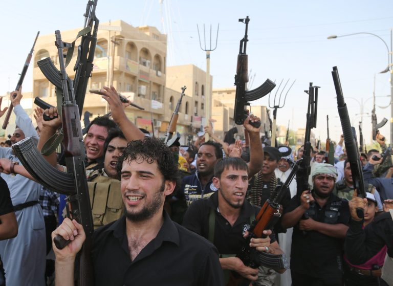 Shiite tribal fighters raise their weapons and chant slogans against the al-Qaida-inspired Islamic State of Iraq and the Levant (ISIL) in the northwest Baghdad's Shula neighborhood, Iraq, Monday, June 16, 2014. Sunni militants captured a key northern Iraqi town along the highway to Syria early on Monday, compounding the woes of Iraq's Shiite-led government a week after it lost a vast swath of territory to the insurgents in the country's north. (AP Photo/ Karim Kadim)