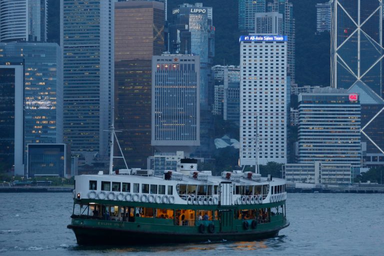 A star ferry sails across the 28-story, Chinese People's Liberation Army Forces Hong Kong Building, center, at the Hong Kong's Victoria Harbor Thursday, July 17, 2014. As skyscrapers around Hong Kong harbor shot out laser beams and turned themselves into giant digital displays in their synchronized nightly light show, one innocuous 28-story building at the waterâs edge had stayed dark for months, clad in bamboo scaffolding for a facelift.  (AP Photo/Kin Cheung)