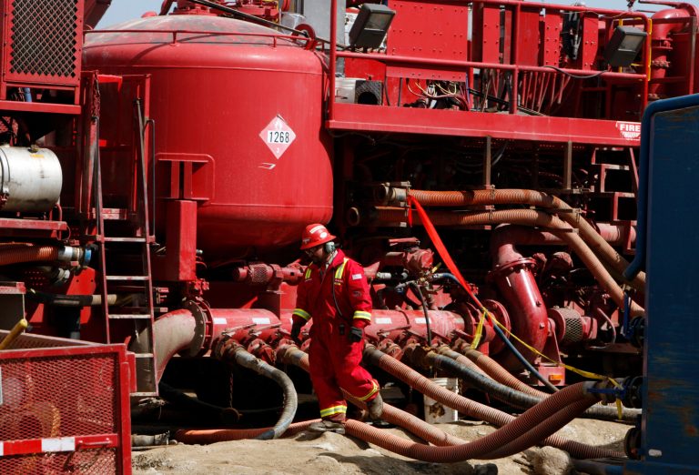 In this Wednesday, April 15, 2009 file photo, an unidentified worker steps through the maze of hoses being used at a remote fracking site being run by Halliburton for natural-gas producer Williams in Rulison, Colo. (AP Photo/David Zalubowski, File)