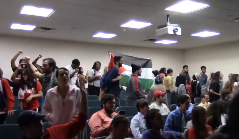 Student activists held Palestinian flags, marched around the room, and shouted over Horowitz's remarks. (Image courtesy screenshot)